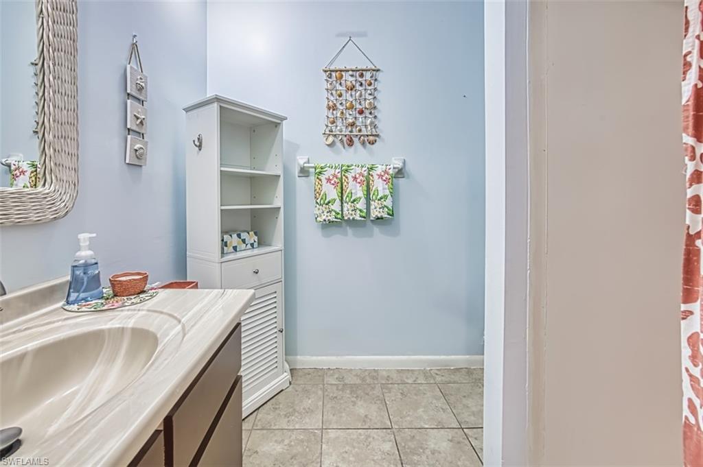 Full bathroom with vanity and tile patterned flooring