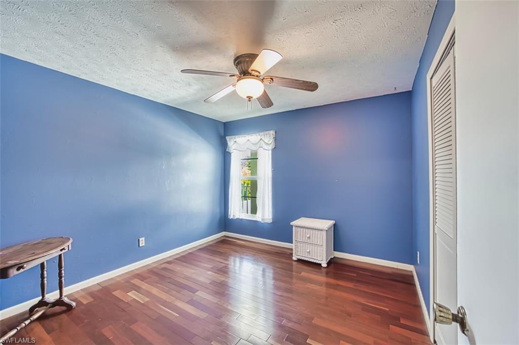 Spare room with wood finished floors, a textured ceiling, and ceiling fan