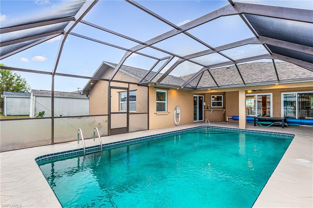 Screened-in swimming pool enclosure featuring a concrete pool deck, tile coping, and clear water - Virtually Edited Image
