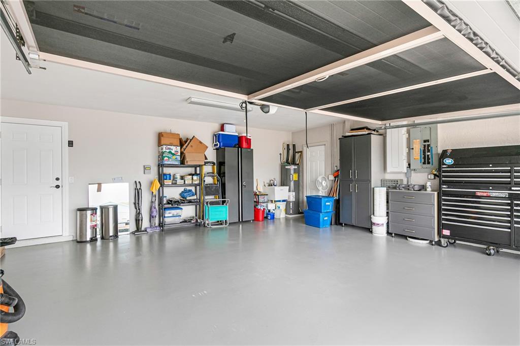 Spacious garage featuring a durable light gray floor, white walls, and overhead lighting - Virtually Edited Image