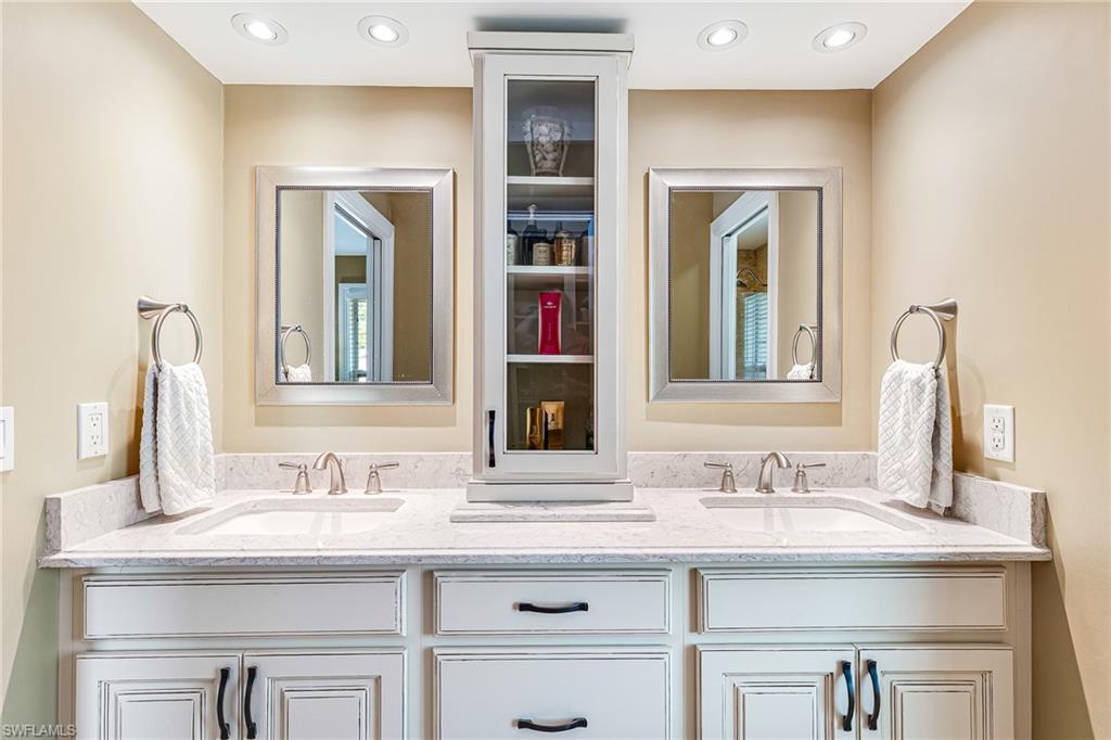 Dual vanity with white cabinetry, light-colored countertop, and brushed nickel fixtures - Virtually Edited Image