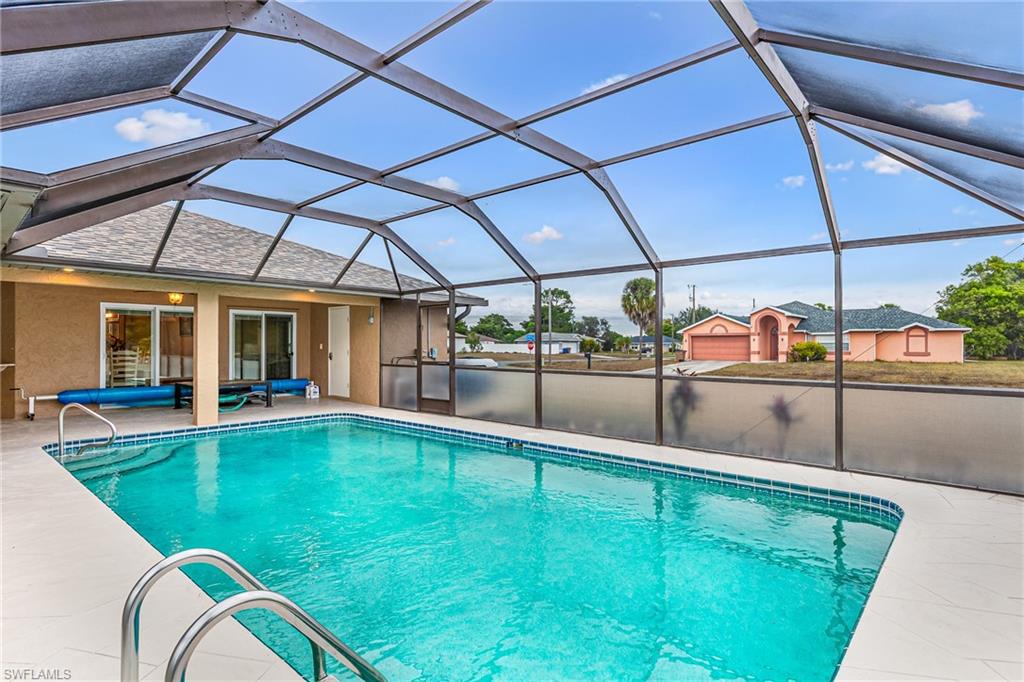 Screened lanai featuring a swimming pool with integrated steps, a tiled waterline, and a white deck surround - Virtually Edited Image