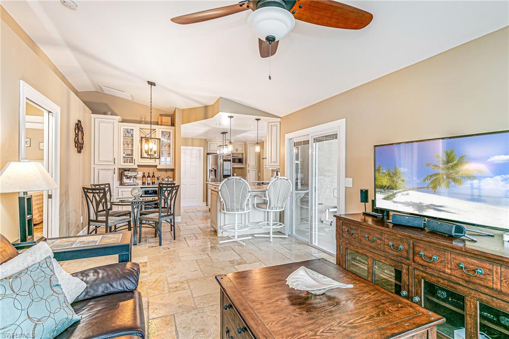 Open-concept living space featuring vaulted ceilings and tile flooring - Virtually Edited Image