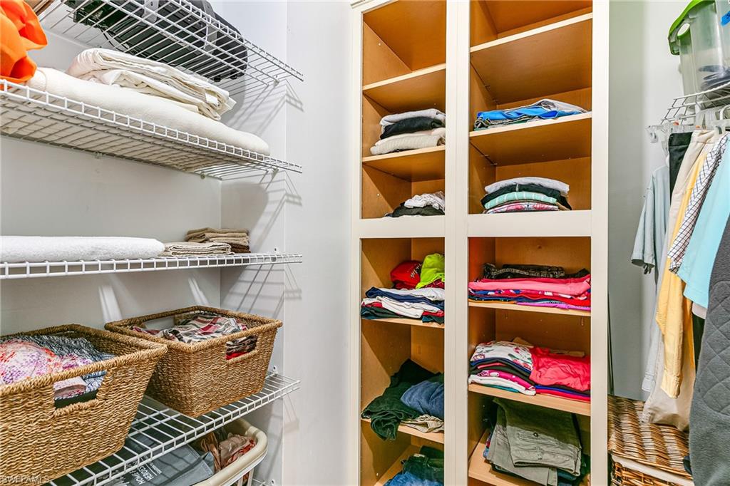 Custom closet system featuring built-in cabinetry with multiple shelves and wire shelving units - Virtually Edited Image