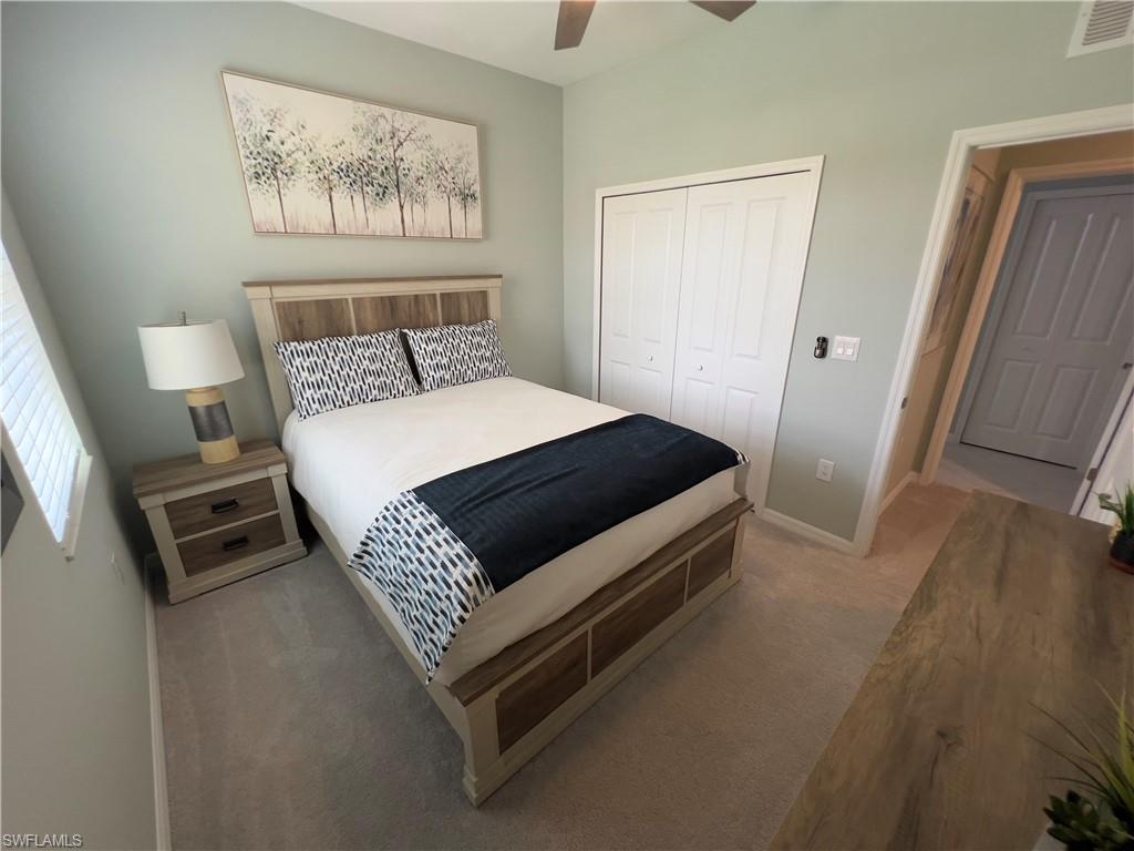 Bedroom with a closet, ceiling fan, and carpet