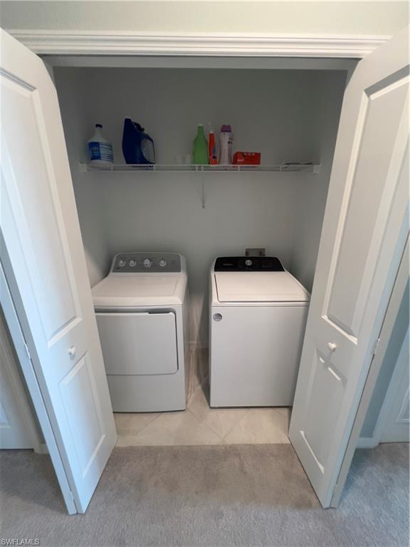 Washroom with light colored carpet and separate washer and dryer