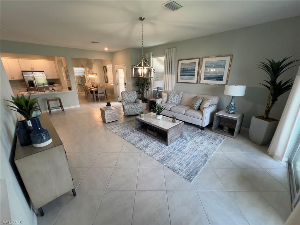 Living room with light tile patterned floors and a chandelier