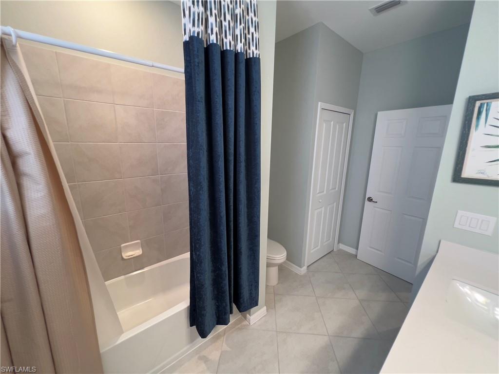 Full bathroom featuring vanity, toilet, shower / tub combo, and tile patterned floors