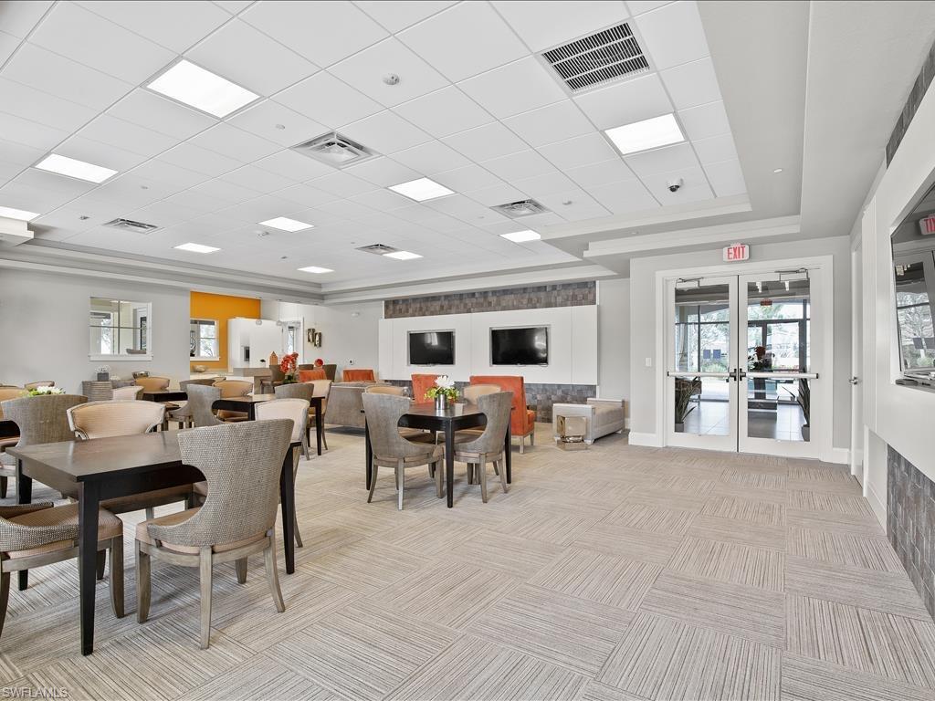 Carpeted dining area featuring a raised ceiling, french doors, and a drop ceiling
