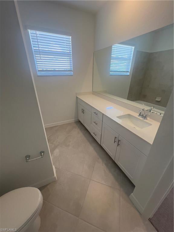 Bathroom with toilet, tile patterned flooring, and vanity