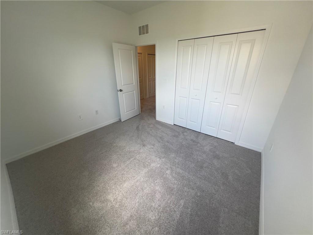 Unfurnished bedroom with a closet and carpet flooring