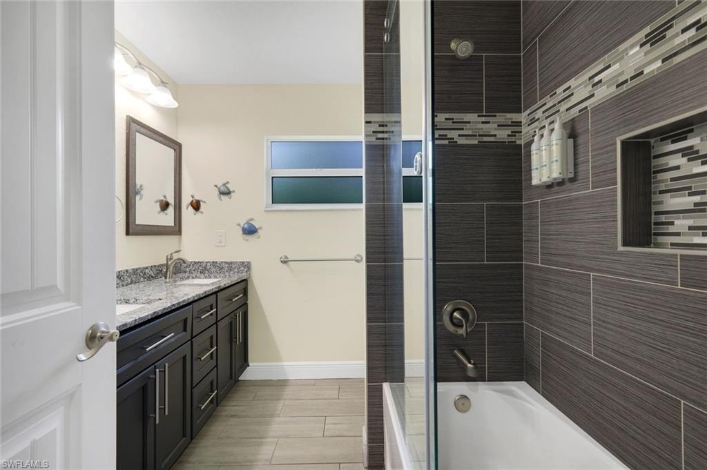 Full bathroom with a dual vanity featuring a granite countertop and undermount sinks