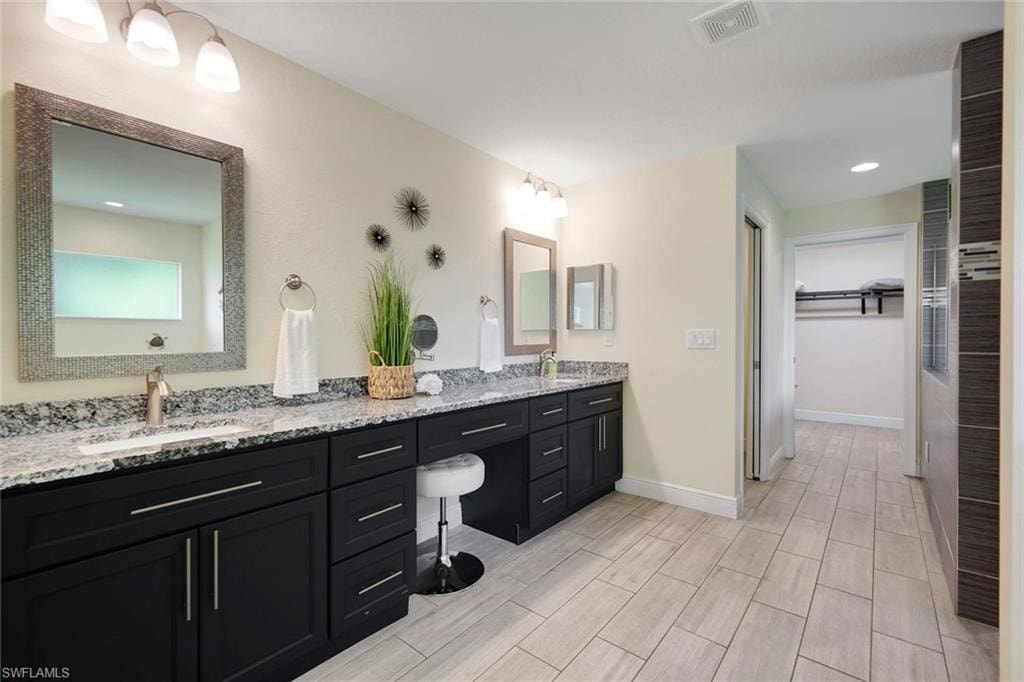 Dual vanity with granite countertops, undermount sinks, and dark wood cabinetry