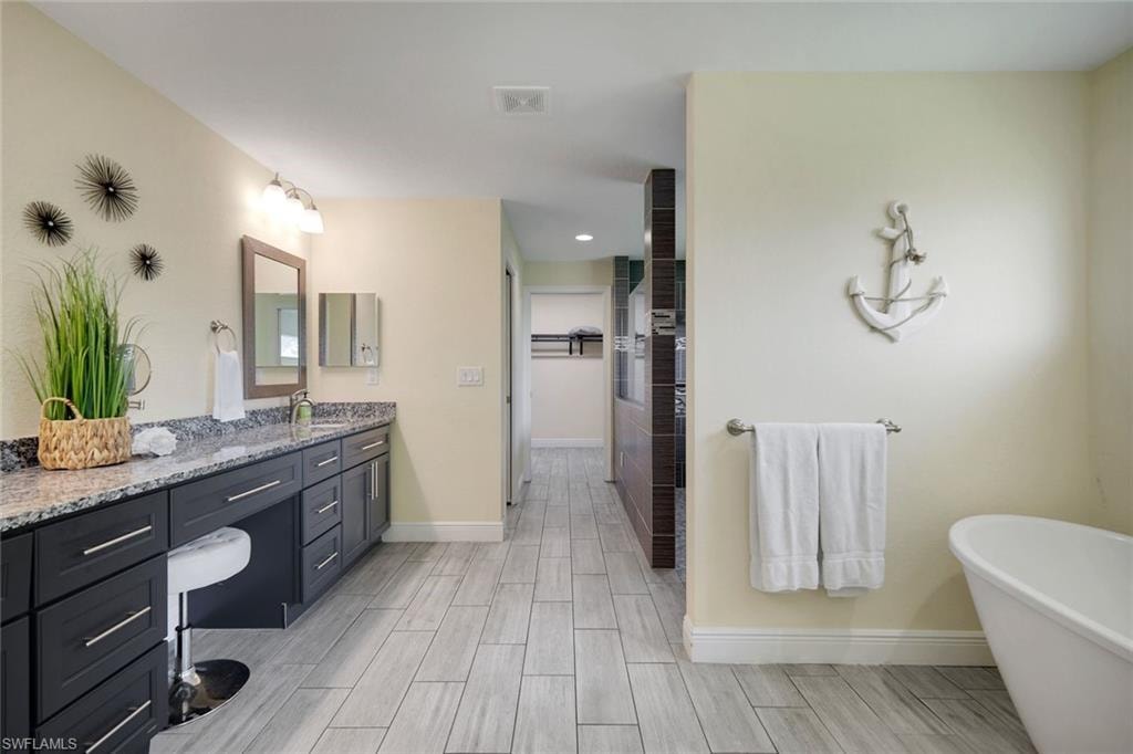 Spacious bathroom featuring an elongated double vanity with dark cabinetry and a light-toned countertop