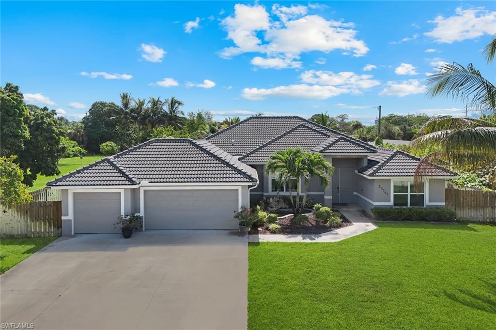 Spacious single-story residence featuring a tile roof, two-car garage, and a manicured front lawn