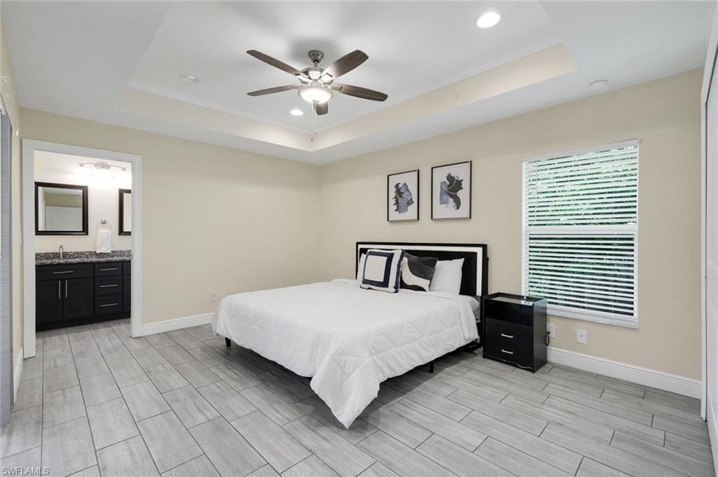 Spacious room featuring wood-finish flooring, a tray ceiling, and recessed lighting