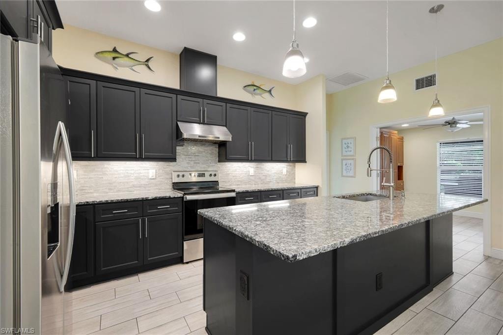 Kitchen featuring a central island with a granite countertop and integrated sink
