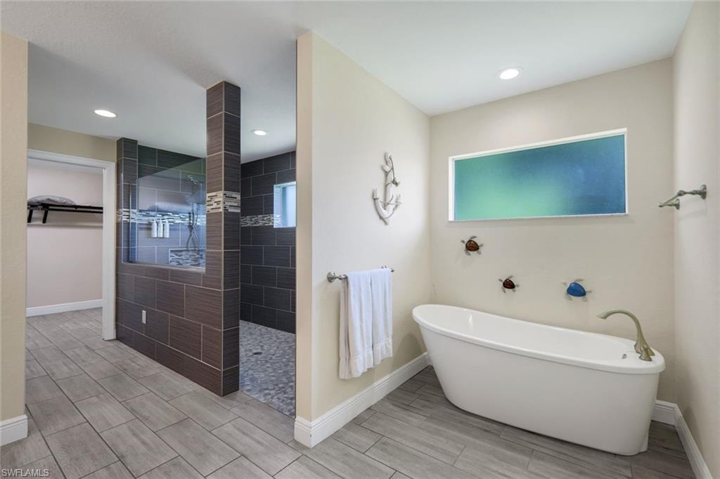 Freestanding soaking tub with floor-mounted faucet