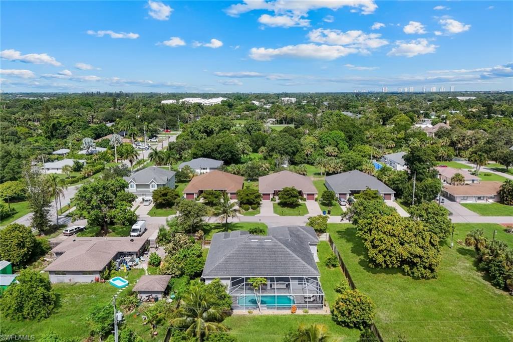 Expansive residential neighborhood featuring numerous single-story homes, mature landscaping, and a distant skyline