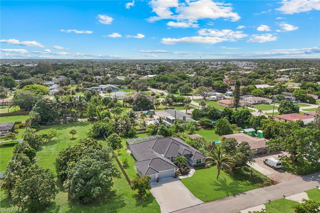 Contemporary single-story residence with a dark tile roof, an attached two-car garage, and a screened lanai