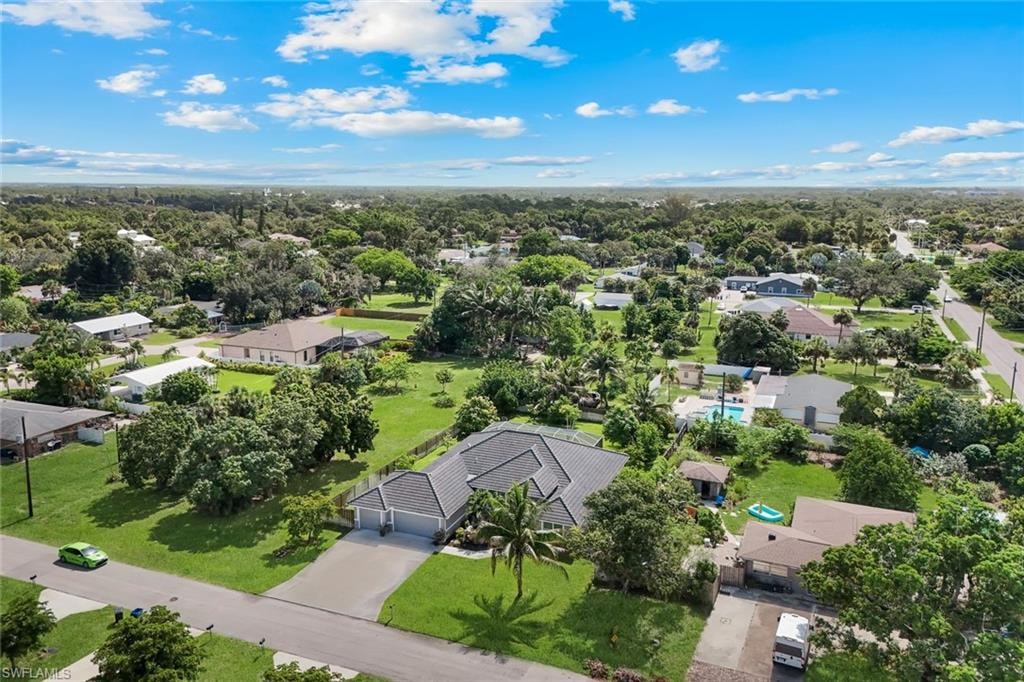 Expansive suburban property featuring lush green lawns and abundant mature trees