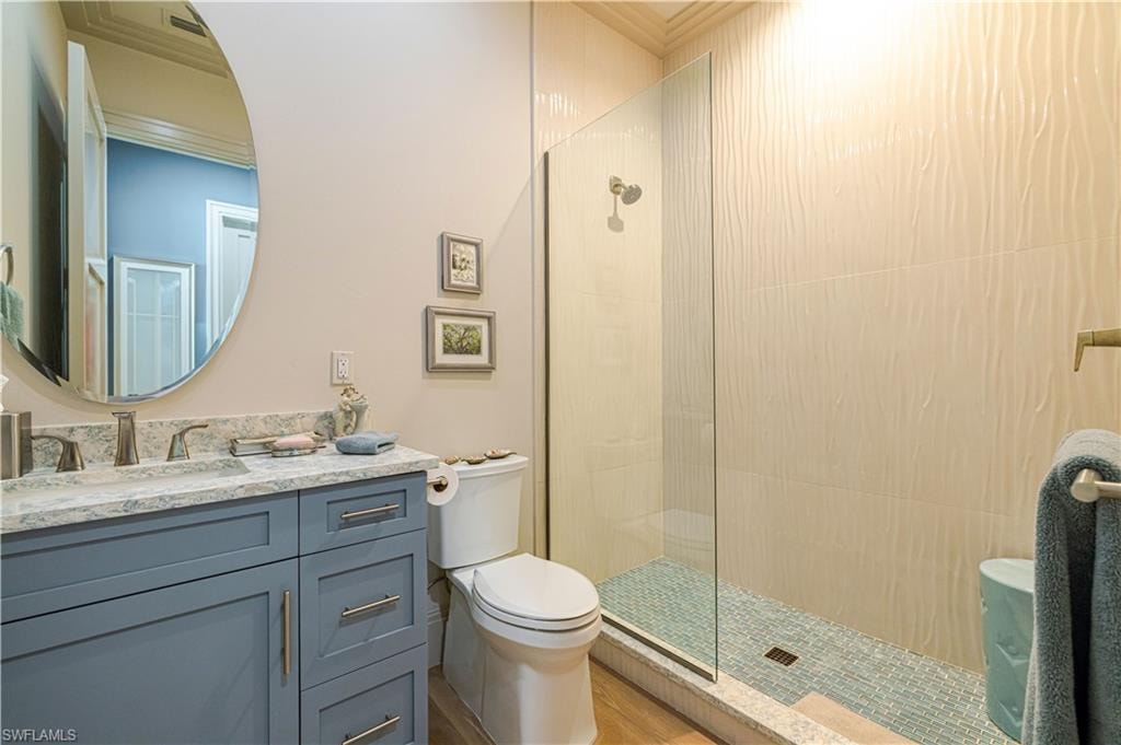 Bathroom featuring a glass-enclosed shower with textured wall tiles and a mosaic tile floor