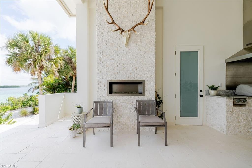 Outdoor living space featuring a textured stone fireplace with a built-in linear fire feature