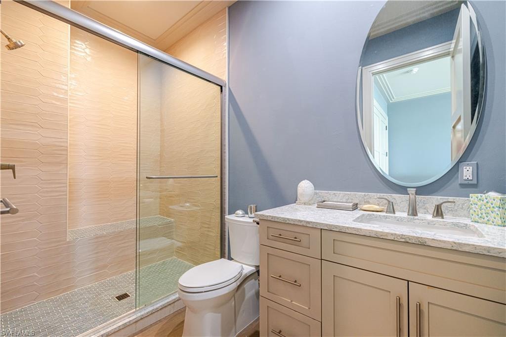 Modern bathroom featuring a glass-enclosed shower with textured wall tile and mosaic floor tile