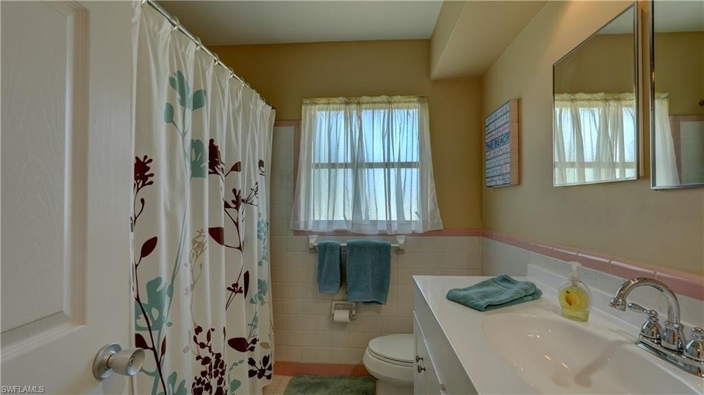 Guest bathroom with combo tub & shower and linen closet