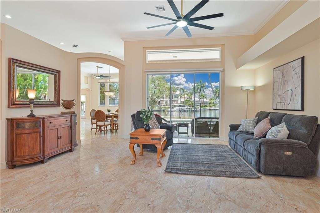 Living area with light-toned tile flooring and an arched doorway
