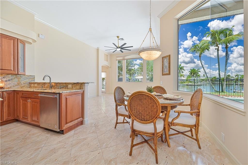 Expansive dining area featuring large windows, vaulted ceilings, and tile flooring