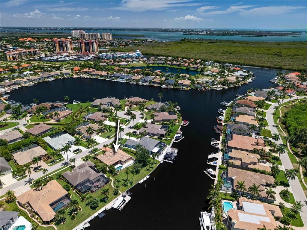 Waterfront property featuring a private boat dock, pool, and mature palm trees