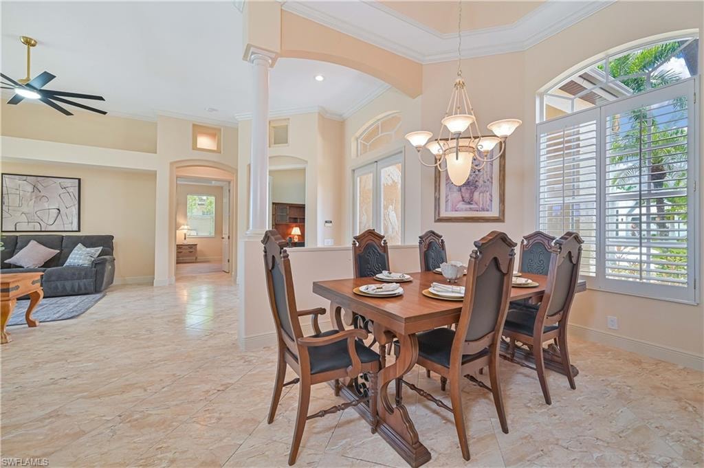Formal dining area featuring a decorative chandelier, plantation shutters, arched windows, and tile flooring