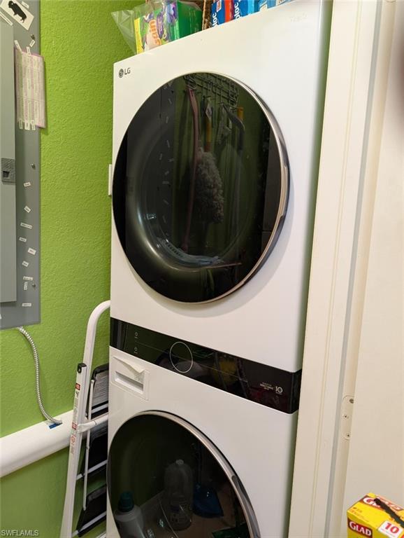 Laundry area with stacked washer / dryer and a textured wall