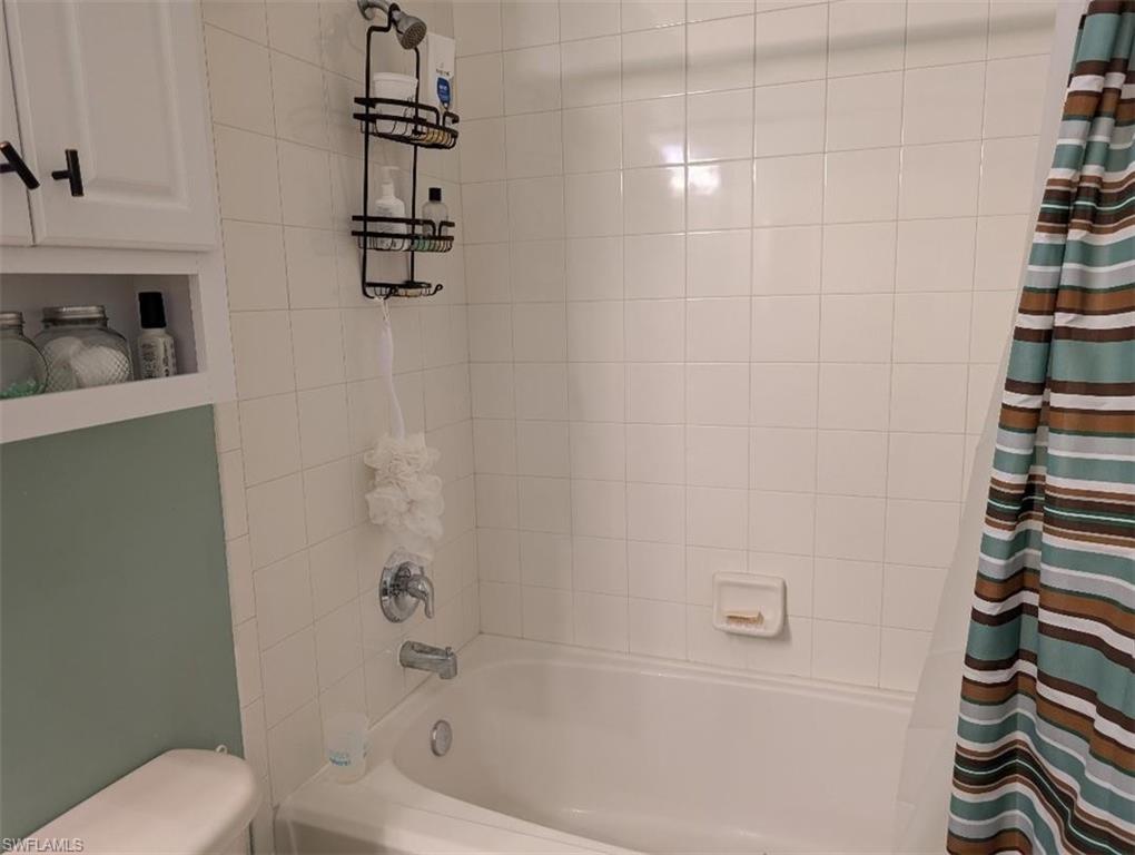Bathroom with shower / bath combination with curtain