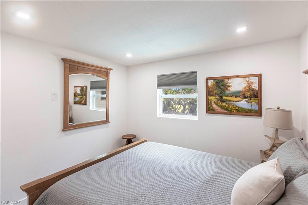 Bedroom featuring recessed lighting, a window with a roller shade, and light-toned walls