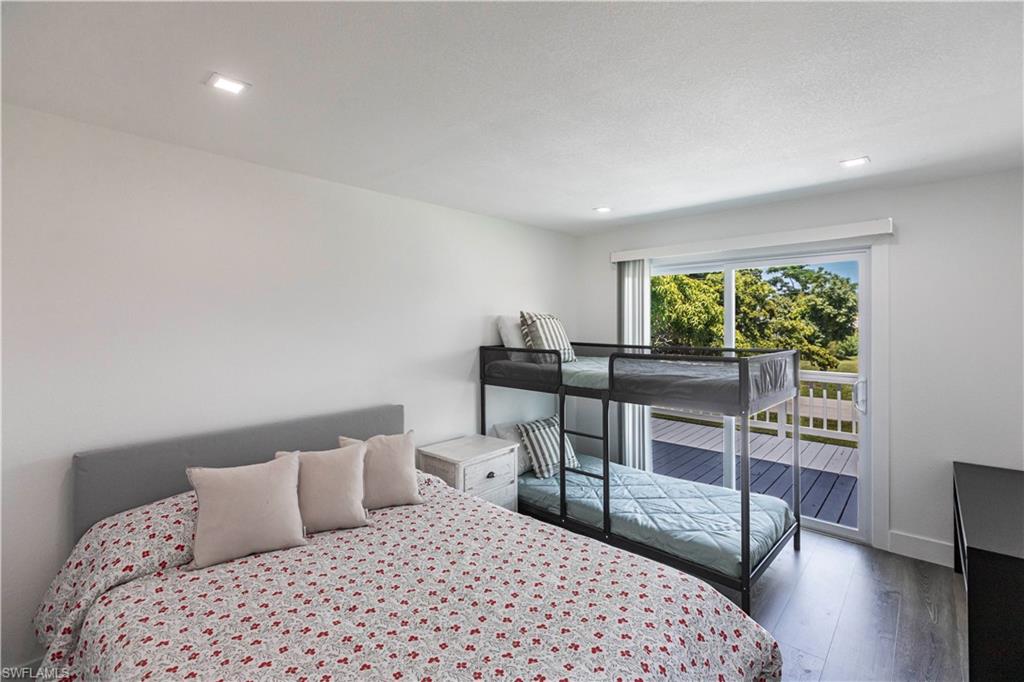 Bright room featuring recessed lighting, dark wood-finish flooring, and a sliding glass door opening to an outdoor deck