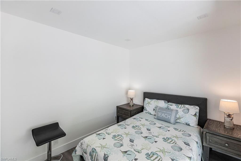 Recessed ceiling lighting, white walls, and dark wood-finish flooring