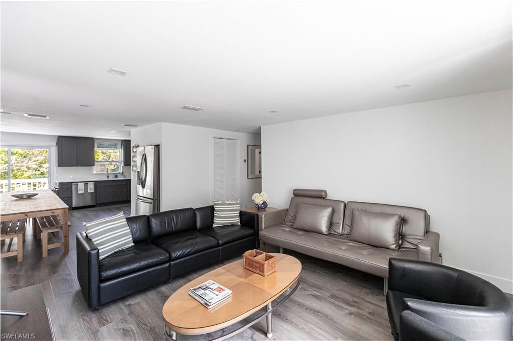 Open-concept living space featuring wood-finish flooring and recessed lighting