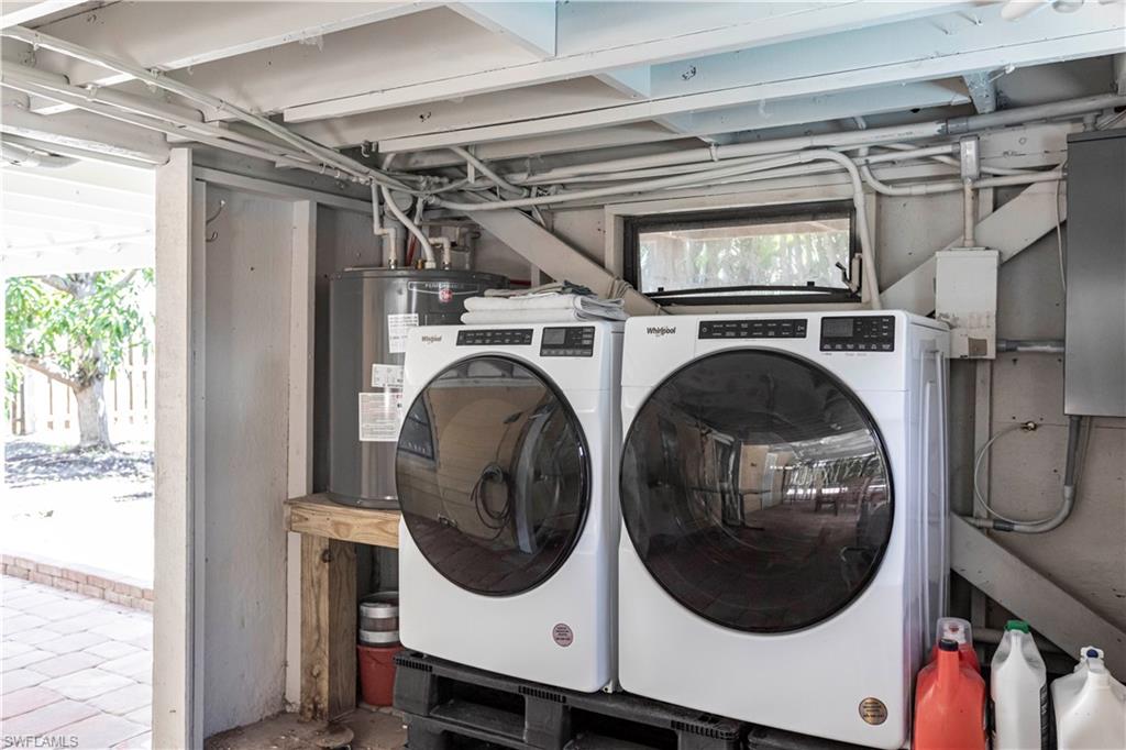 Dedicated utility area featuring a water heater, laundry appliances, and a wall-mounted electrical panel