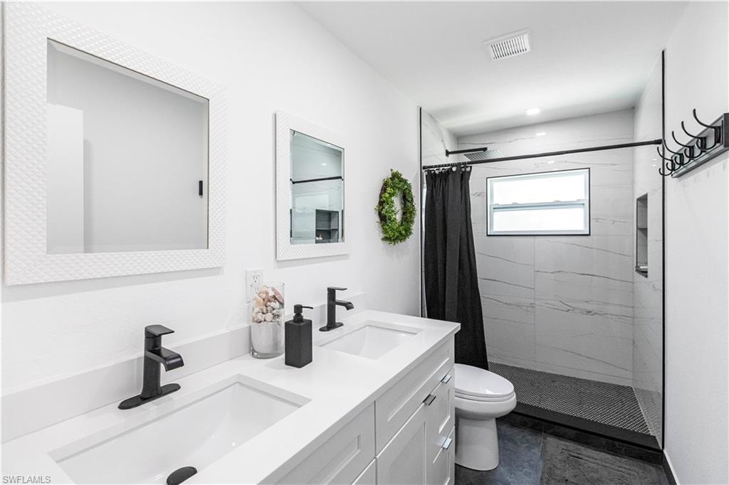 Dual vanity with integrated sinks and matte black fixtures, set against white cabinetry