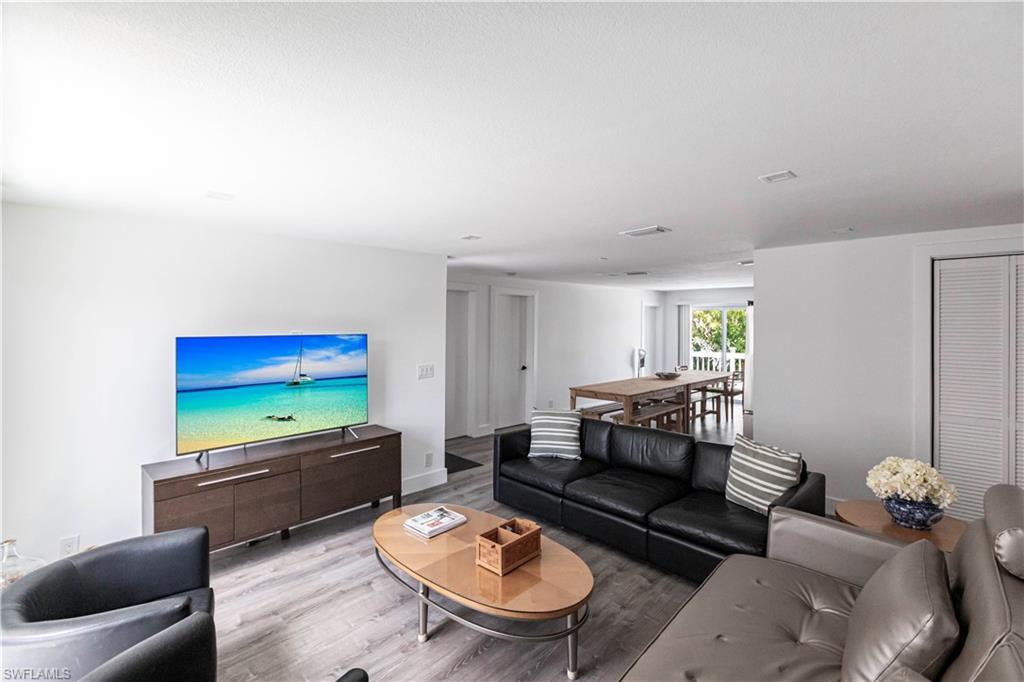 Open-concept living space featuring wood-finish flooring, recessed lighting, and white walls