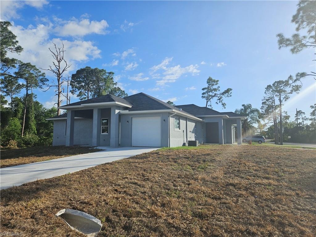 View of front of house with cooling unit, stucco siding, an attached garage, and concrete driveway