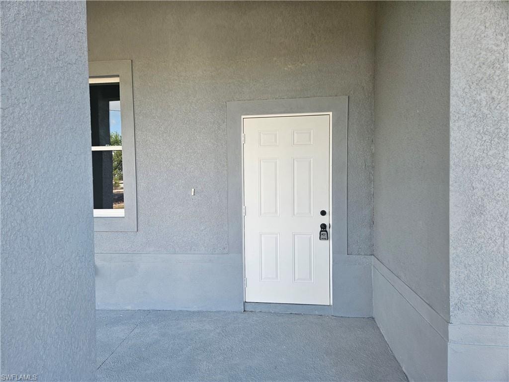 View of exterior entry featuring stucco siding