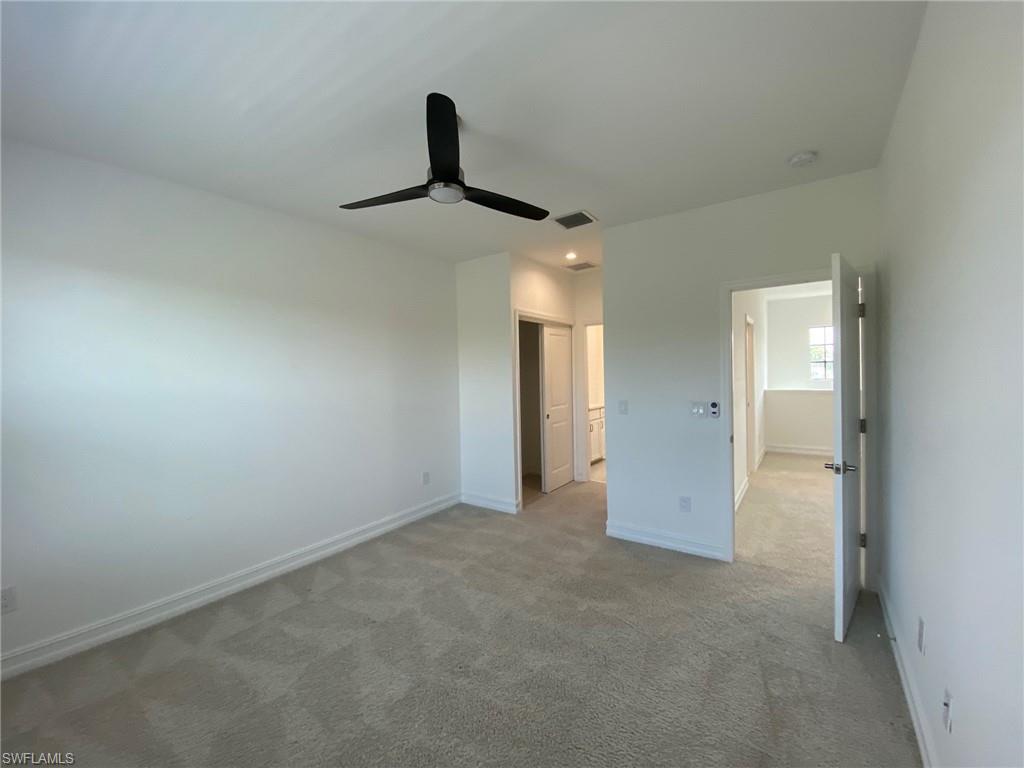Carpeted interior space featuring a modern black ceiling fan
