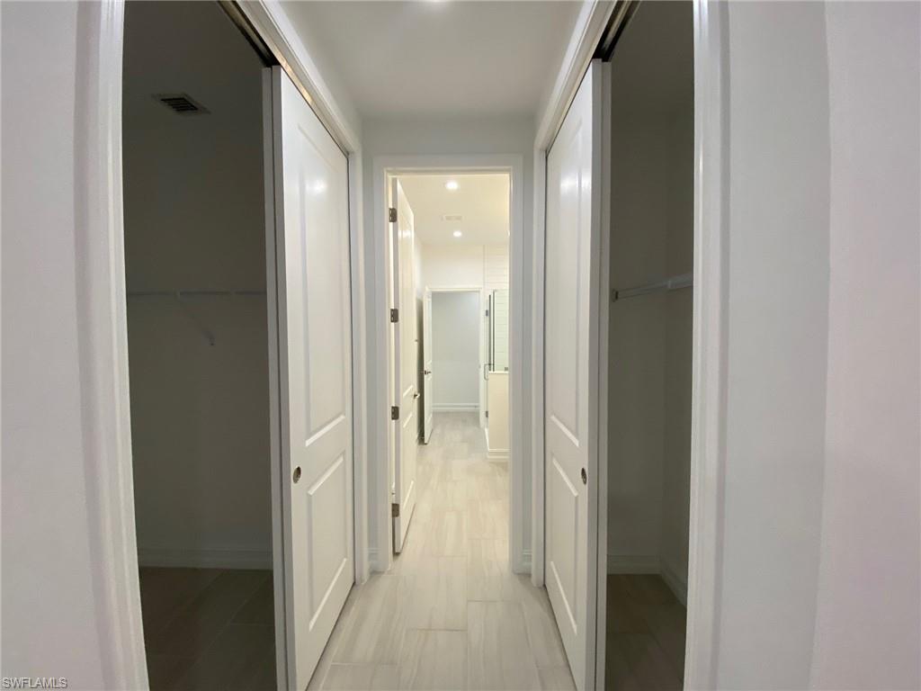 Hallway featuring light wood-finish flooring, recessed lighting, and white panel doors