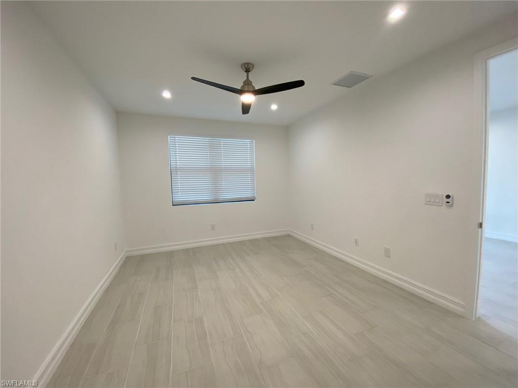 Room featuring light-toned tile flooring, a modern ceiling fan, recessed lighting, and a single window with blinds
