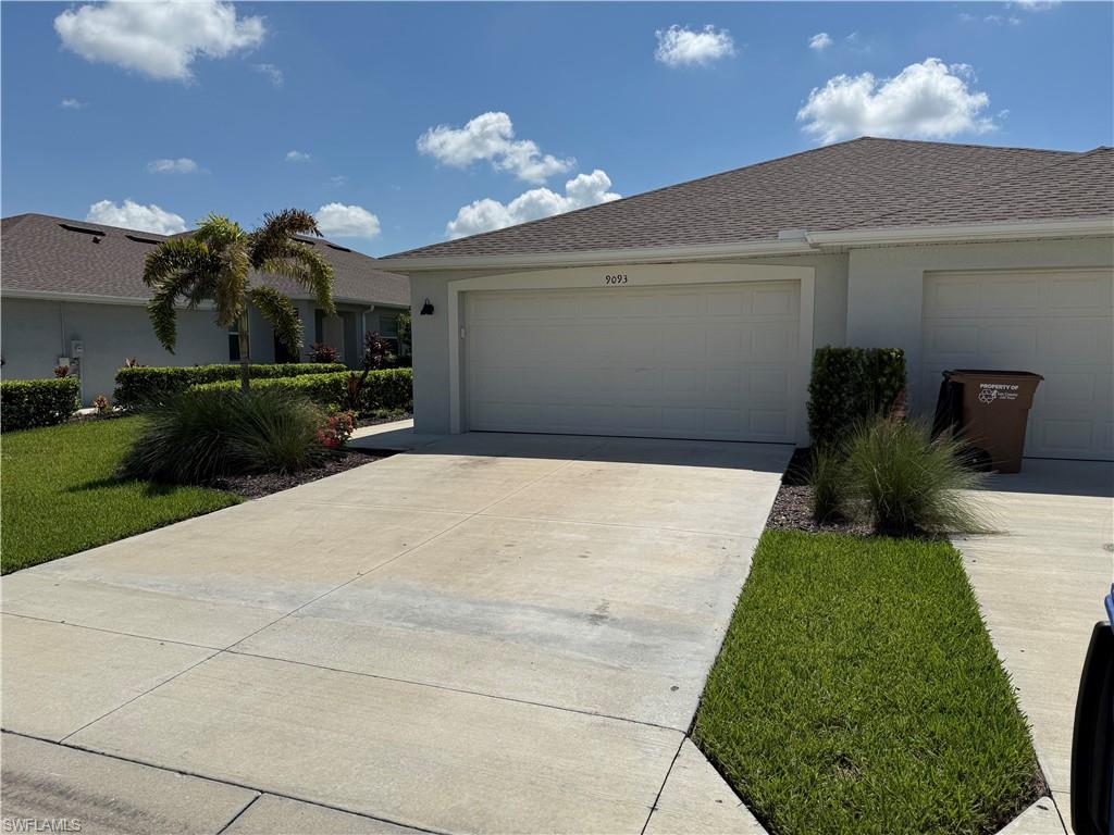 Concrete driveway leading to a two-car garage with a textured door
