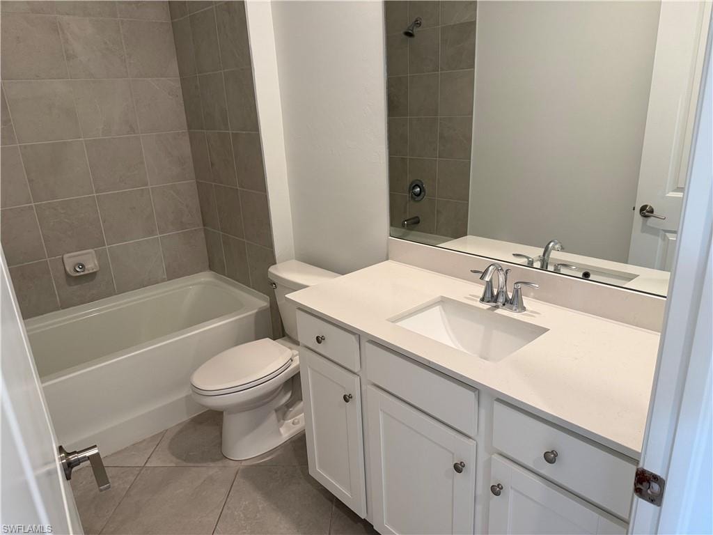 Bathroom featuring a white vanity with an undermount sink, a light-colored countertop, and a large mirror