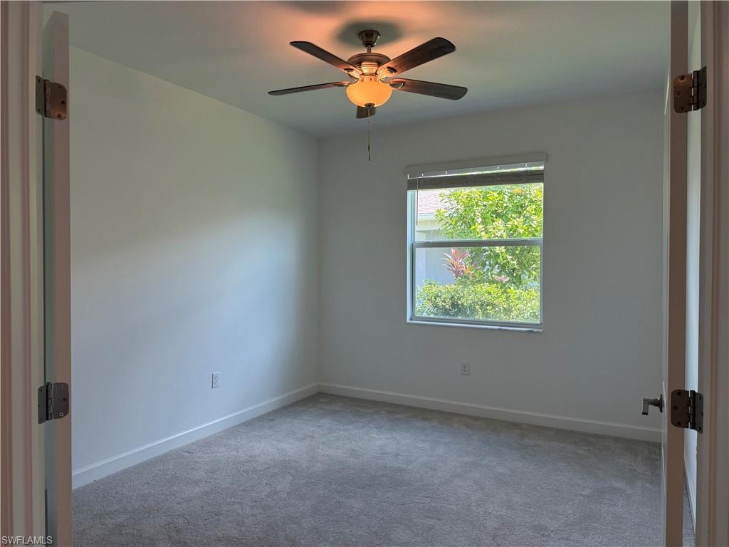 Room featuring light gray carpet, white walls, a single window with blinds, and a ceiling fan with integrated lighting